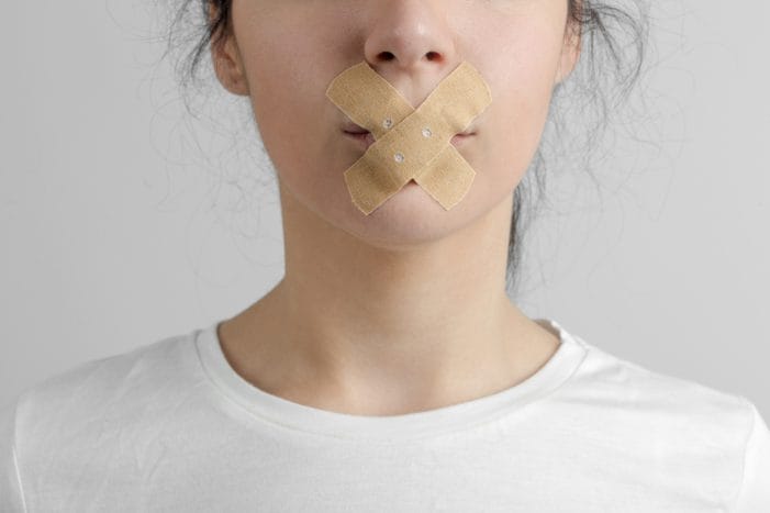 Young woman with tape covering mouth Young woman with tape covering mouth